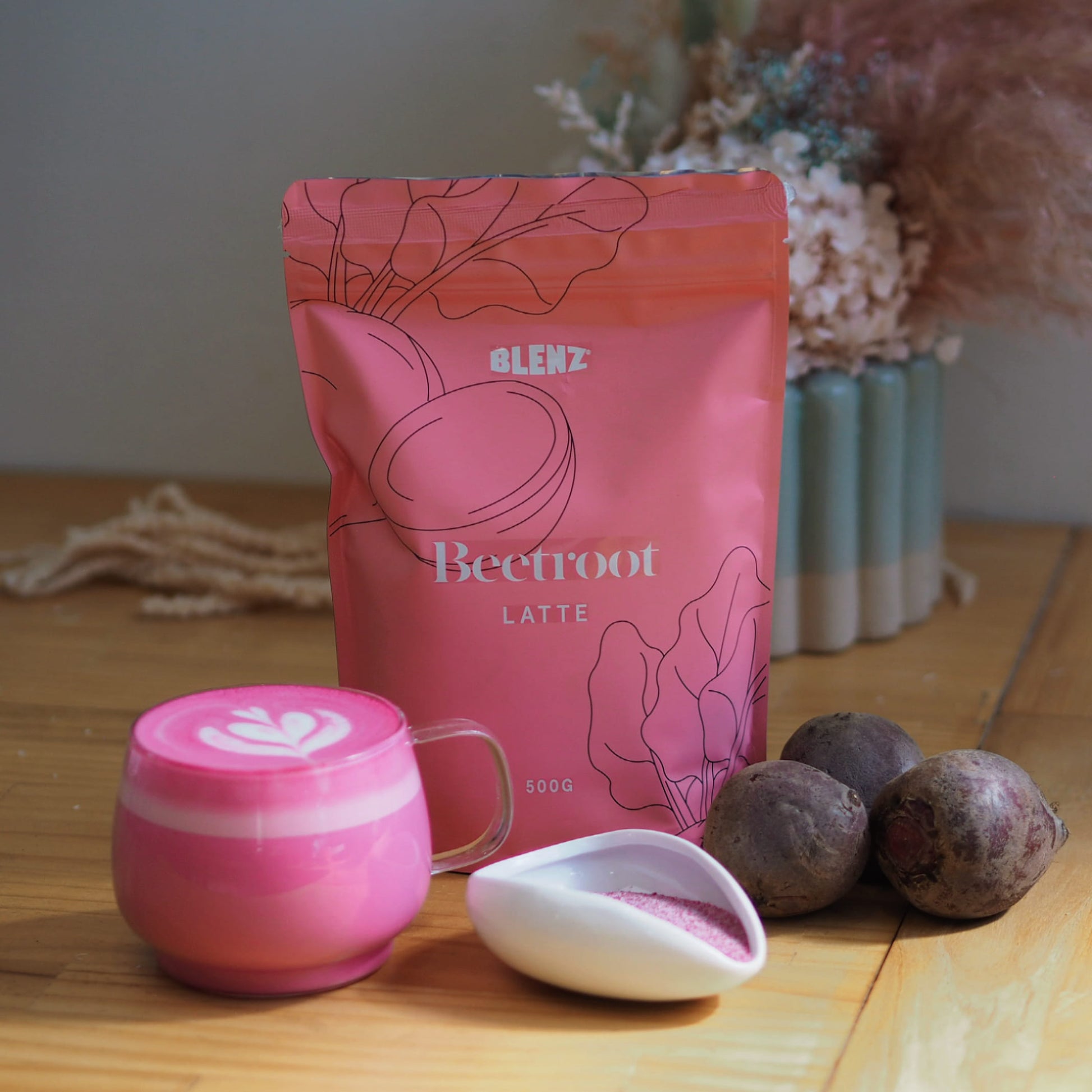 beetroot latte powder in bag and mug on cafe bench